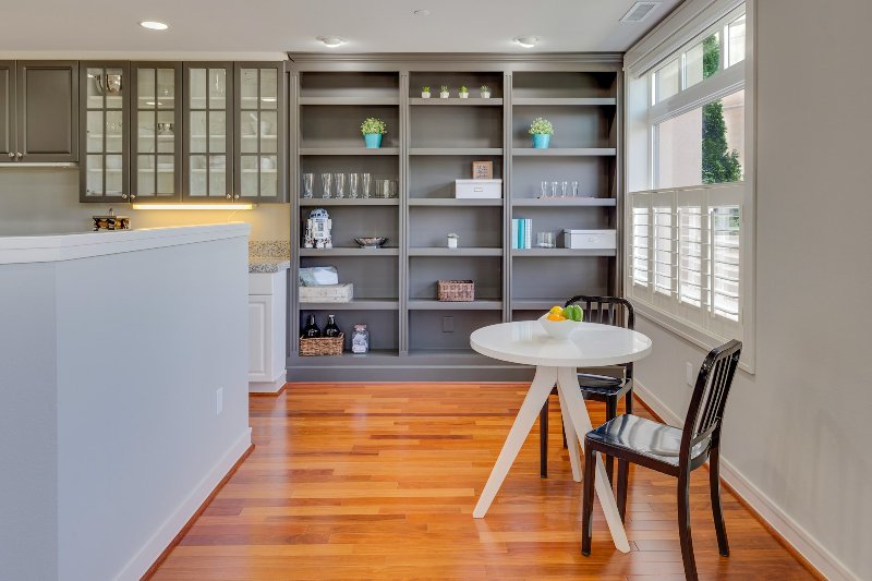 Hardwood floors and grey built in cabinets in a dining area