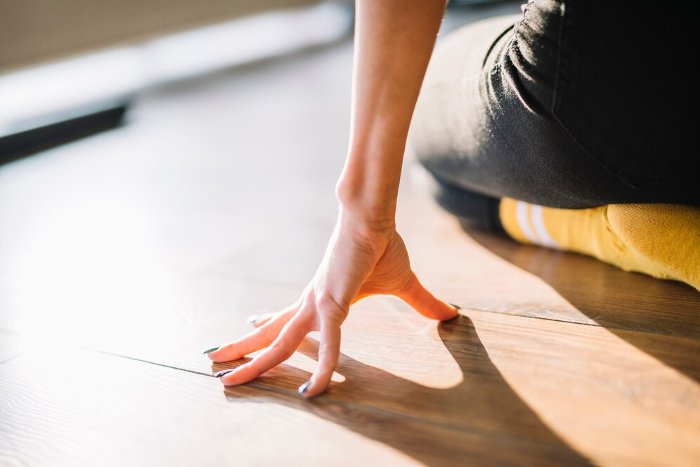 Person kneeling on a hardwood floor